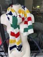 Front view of the scarf draped on a mannequin, showing its colors and knit texture