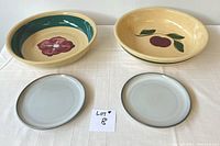 Four items: two large hand painted ovenproof bowls with floral and cherry designs, two smaller plain gray luncheon plates, lot number card included