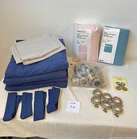 Overall view of all items including duvet covers in packaging, pillow cases, curtain panels, curtain rings, and hardware