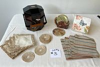 Set of all items including the lacquer ice bucket, coasters sets, linen napkins, and paper napkins arranged on white cloth