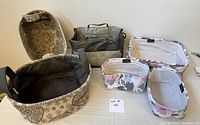 Photo of all fabric storage bins and the shower caddy arranged on a flat surface, showing floral and paisley prints and the shower caddy's compartments and handles.