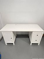 Front view of fully assembled white Ikea Hemnes desk, showing two drawers on the right and a cabinet with door on the left.