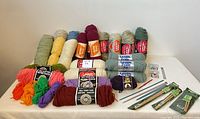 Overview of yarn skeins and knitting accessories on table