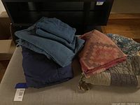 Similar photo with slightly different perspective of the assorted blankets and coverlets.