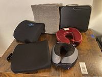 All six items arranged on a wooden table showing back support pillows, neck pillows, a throw pillow, and a lap desk.