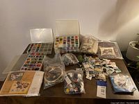 Wide view of embroidery floss sets, kits, and loose skeins spread on table