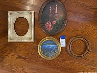 Top-down view of five items arranged on wood floor showing all frames and art pieces