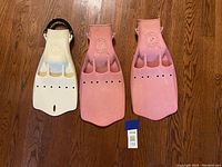 Front view of three scuba fins showing logos, toe pockets, and ventilation holes.