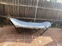 Full view of the assembled grey metal frame freestanding hammock with attached shade canopy, showing overall condition and size.