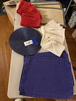 Photo showing red and white cloth napkins with other placemats on table.