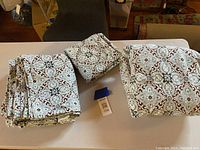 Folded sheets and pillowcases laid flat on table showing full pattern and quantity.
