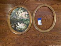 Lot showing both the springtime-themed oval painting and the matching empty wood frame side by side on a wooden floor.