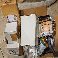 Overview of multiple boxes and stacks containing assorted sports cards
