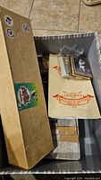 Cardboard box containing various sports card boxes and loose cards inside.