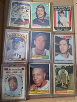 Nine assorted vintage baseball cards featuring players from various teams. Cards are inside plastic sleeves, showing players like Carl Yastrzemski, Dennis Eckersley, John Callison, Willie Mays, Bud Daley, Angel Brazo, Hank Aaron, Willie Tasby, and Larry Osborne.