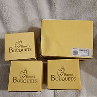 Four yellow boxes labeled Byron's Bouquets, one box lid is missing and shows minor damage