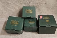 Four original green Harmony Kingdom boxes with gold logo, some visible wear