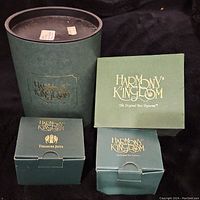Photo of four Harmony Kingdom dark green boxes with gold logo stamped, displaying the lot of collectible box figurines.