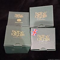Four green Harmony Kingdom boxes with gold logo and text, showing original packaging for four figurines.