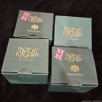 Four Harmony Kingdom boxes showing wear with brand and 'Treasure Jests' labeling