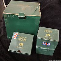 Original green cardboard boxes labeled Harmony Kingdom Treasure Jests with British flag stickers, showing box condition and quantity.