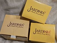 Three original Jardinia by Martin Perry Studios boxes in yellow and tan colors.