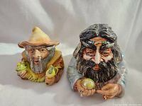 Front view of both wizard face pots showing detailed ceramic design.