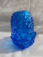 Close-up of the blue hobnail textured glass cover showing the rounded top and pronounced textured design.