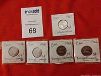 Five Canadian 5 cent coins, four featuring Young Elizabeth II dated 1956, 1960, 1961, 1962, plus one 1967 Confederation coin, each mounted in white cardboard holders with handwritten labels.