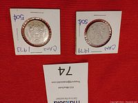 Two individual Canadian half dollar coins in white cardboard flip holders, dated 1973 and 1979.