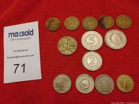 Photo of the Yugoslavian coin assortment on a red cloth background and a MaxSold auction lot tag 71.