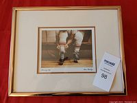 Framed print with coppertone metal frame against a red background, showing overall piece.