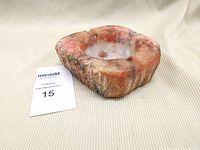 Red marble ashtray angled front view on beige fabric background with white MaxSold card showing lot number.