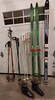 Photo shows full inventory: skis, boots, and poles arranged in a garage setting.