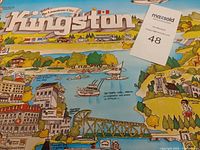 Close-up of Kingston illustrated map poster showing landmarks, boats, and bridge with maxsold lot tag