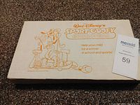 Closed rectangular box of the Walt Disney Sport Goofy Encyclopedia with cartoon Goofy playing tennis and other sports printed in orange on an off-white box.