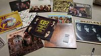 Multiple album covers spread on floor including Beatles, Hendrix, Black Sabbath, Amboy Dukes