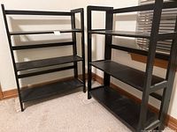 Two black foldable bookshelves side by side on carpeted floor showing overall size and condition