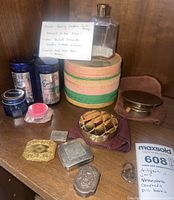 Overview of entire lot showing jars, compacts, pill boxes, beads bottle, and arrowhead with note on Indian burial ground provenance.