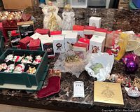 Wide shot of assorted Christmas ornaments, angels, boxed items, and figurines on a marble table