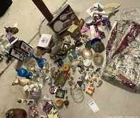 Overview of the entire collection showing various glass trinkets, figurines, boxes, and satin robe wrapped in plastic