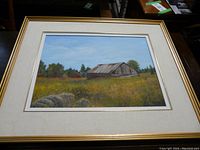 Full front view of framed painting showing barn, meadow, mat and frame