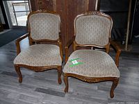 Pair of vintage style side chairs with brown and beige patterned upholstery and carved wood frames.