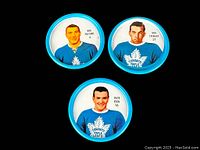 Front view of three metal hockey coins showing portraits of Bob Pulford, Ron Stewart, and Dave Keon in Toronto Maple Leafs jerseys.