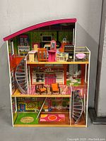Front view of entire dollhouse showing three floors with furniture and staircases