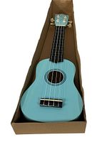 Top down view of blue ukulele in original box showing body, fretboard and tuning keys.