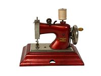 Front view of red vintage Casige child's toy sewing machine on metal base with spool and hand crank visible.