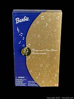 Back of the box showing Barbie branding and festive musical notes design.