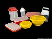 Full lot of vintage Tupperware items in various colors and shapes arranged on black background