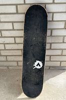 Top view of skateboard deck showing black grip tape with Airwalk logo and typical wear marks